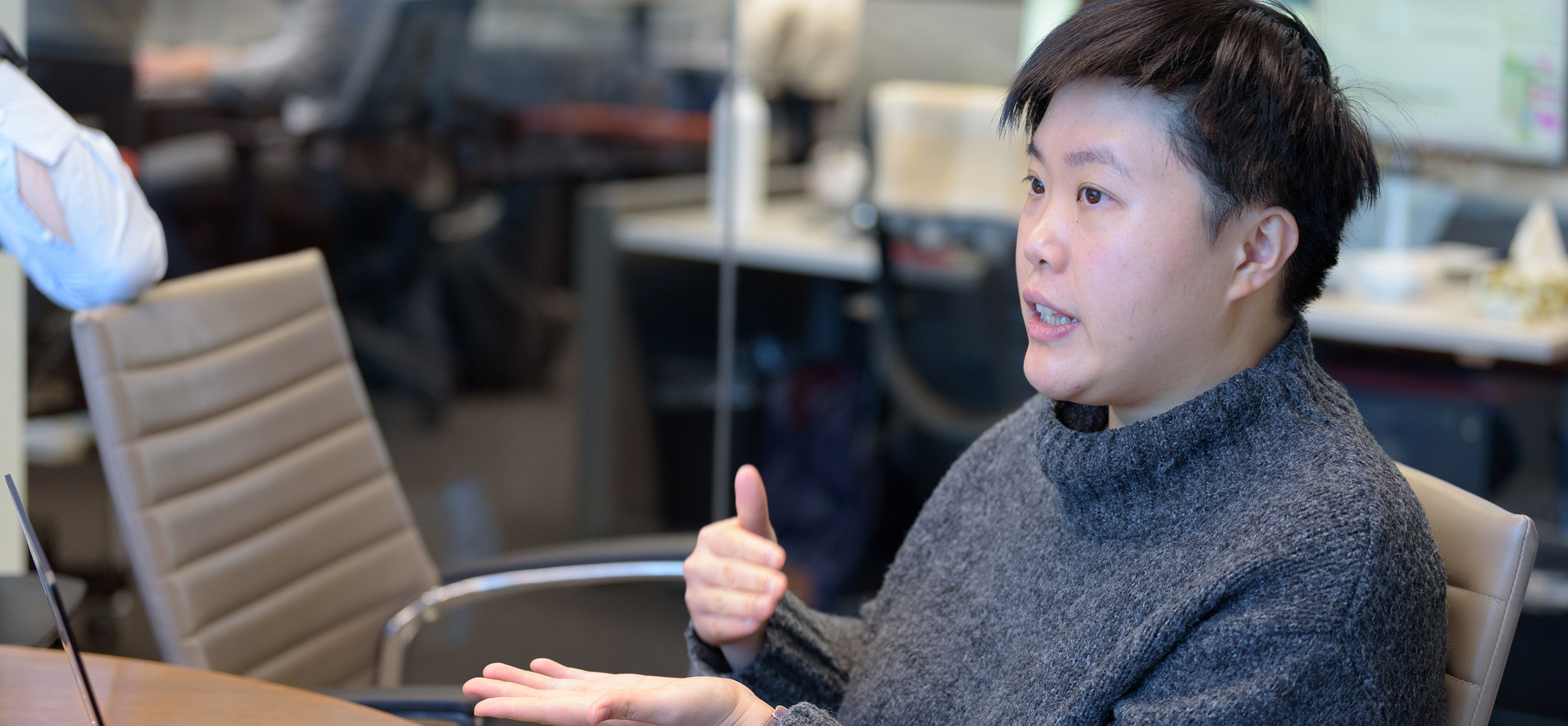 A person in discussion, using their hands to explain a concept.