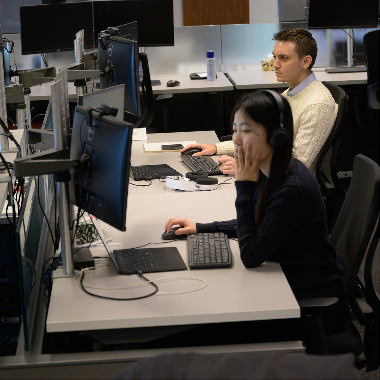 Two Q Team members working at their desks.