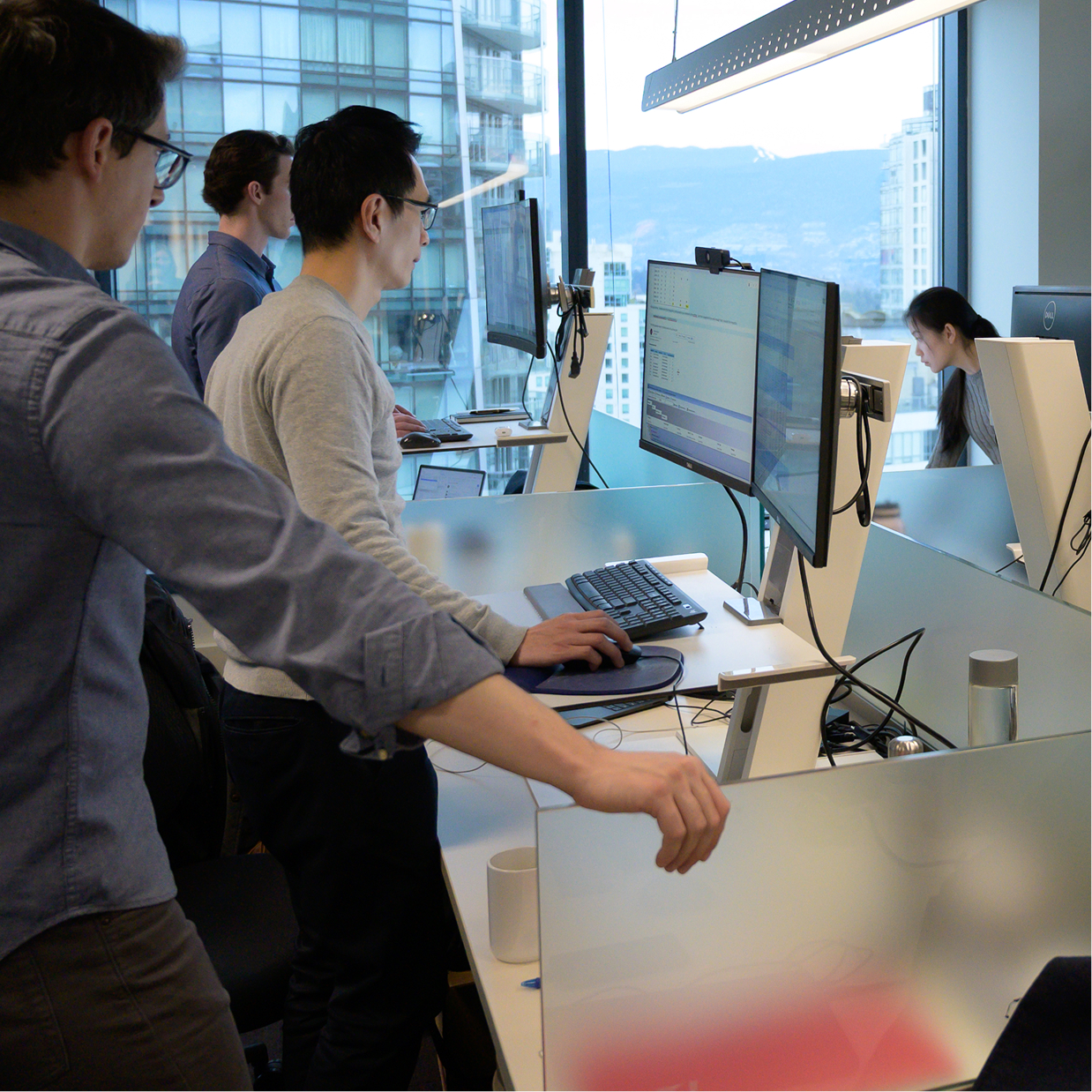 A row of Q Team members working at their standing desks.