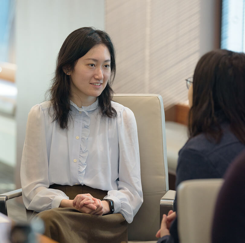 A member of the Q team having a conversation with a coworker who is off to the side.